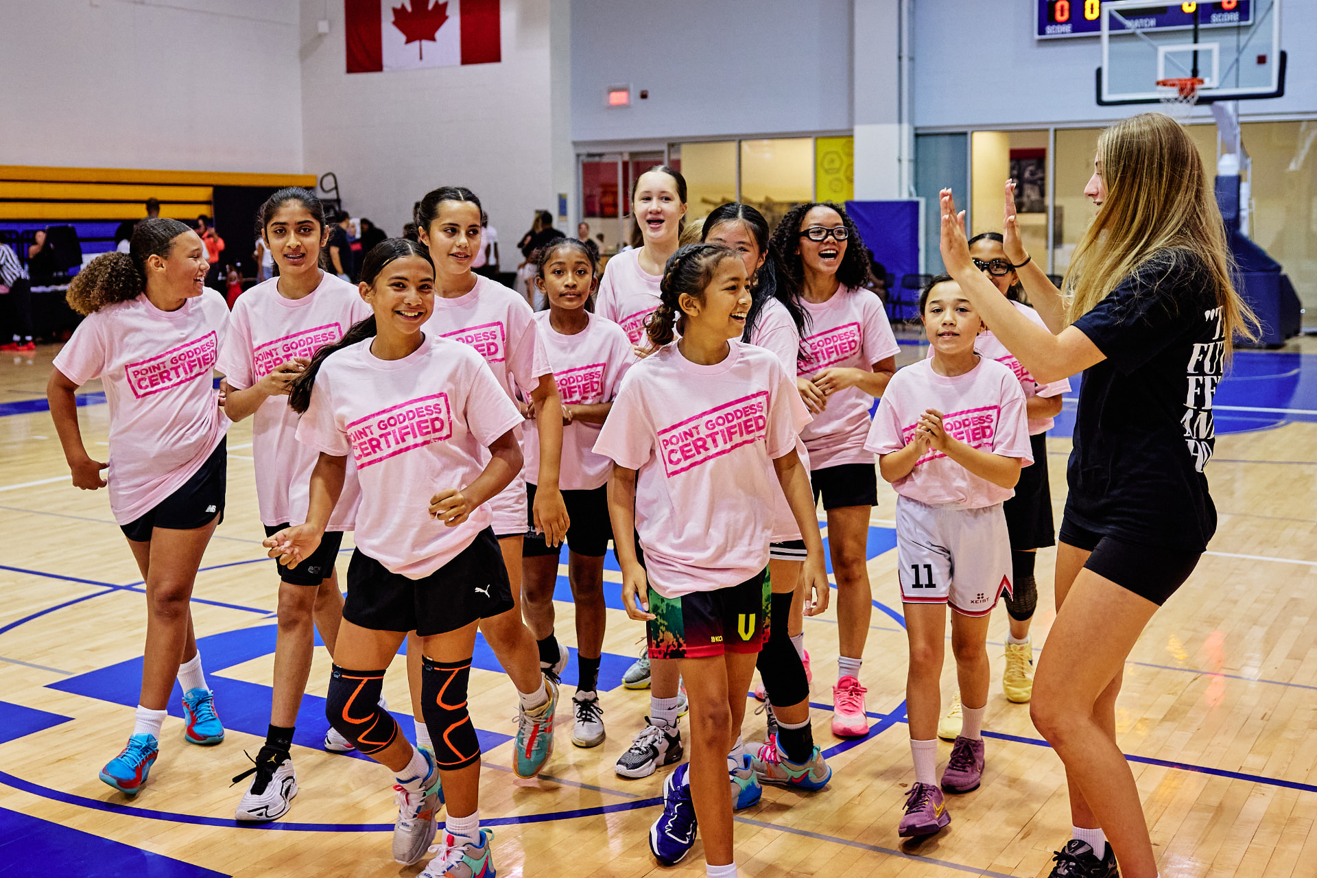 Young players in pink Point Goddess Certified shirts celebrating on the court