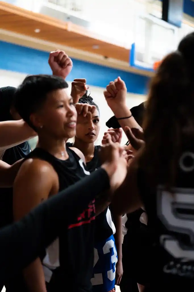 Athletes and mentors putting their hands in together for a huddle